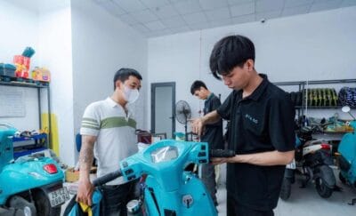 Học viên và thầy hướng dẫn thực hành sửa xe điện trong xưởng